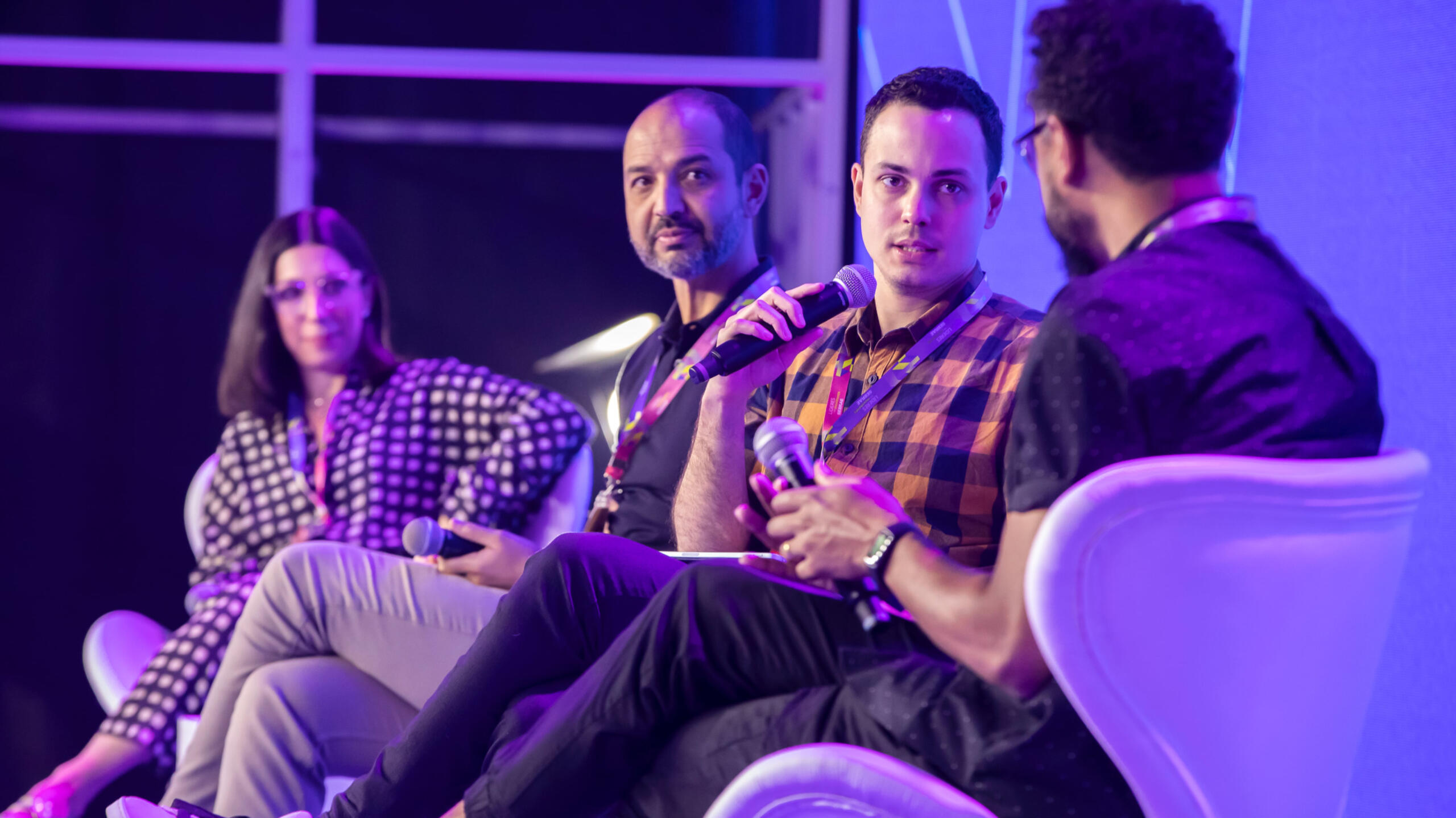 Thássius Veloso é especialista em tecnologia desde 2008 Homem fala ao microfone, enquanto é observado por outras pessoas